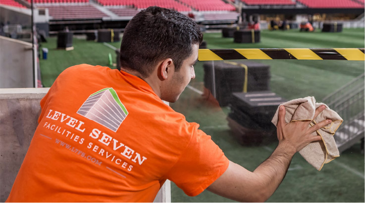 Level Seven staff member wiping down part of a stadium